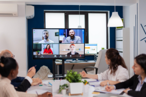 Employees working at an office who are on a video conference call.