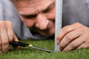 A QA professional measuring grass.